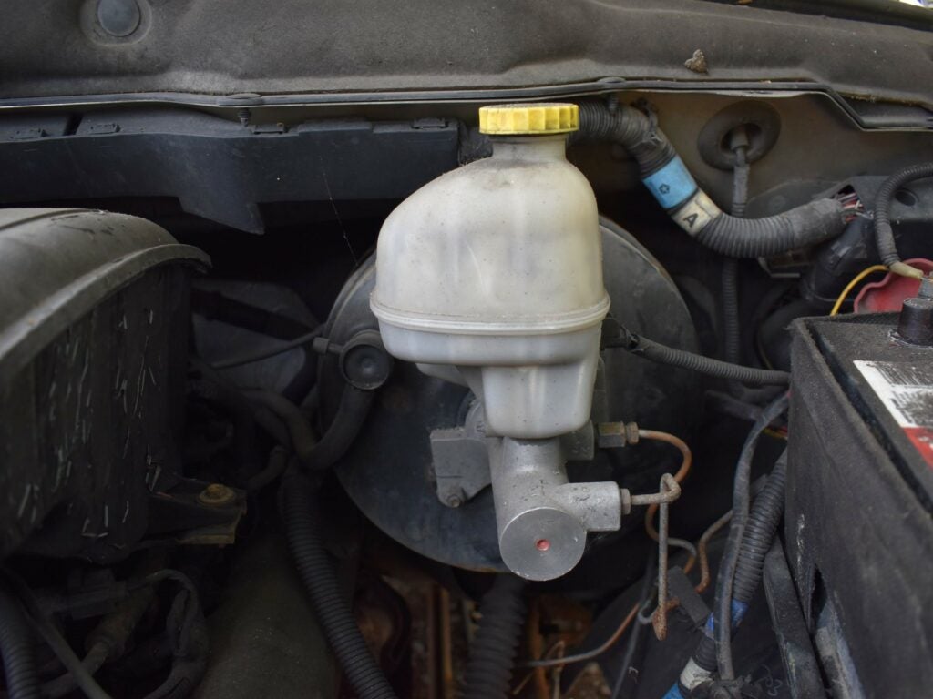 A master brake cylinder inside an engine bay.